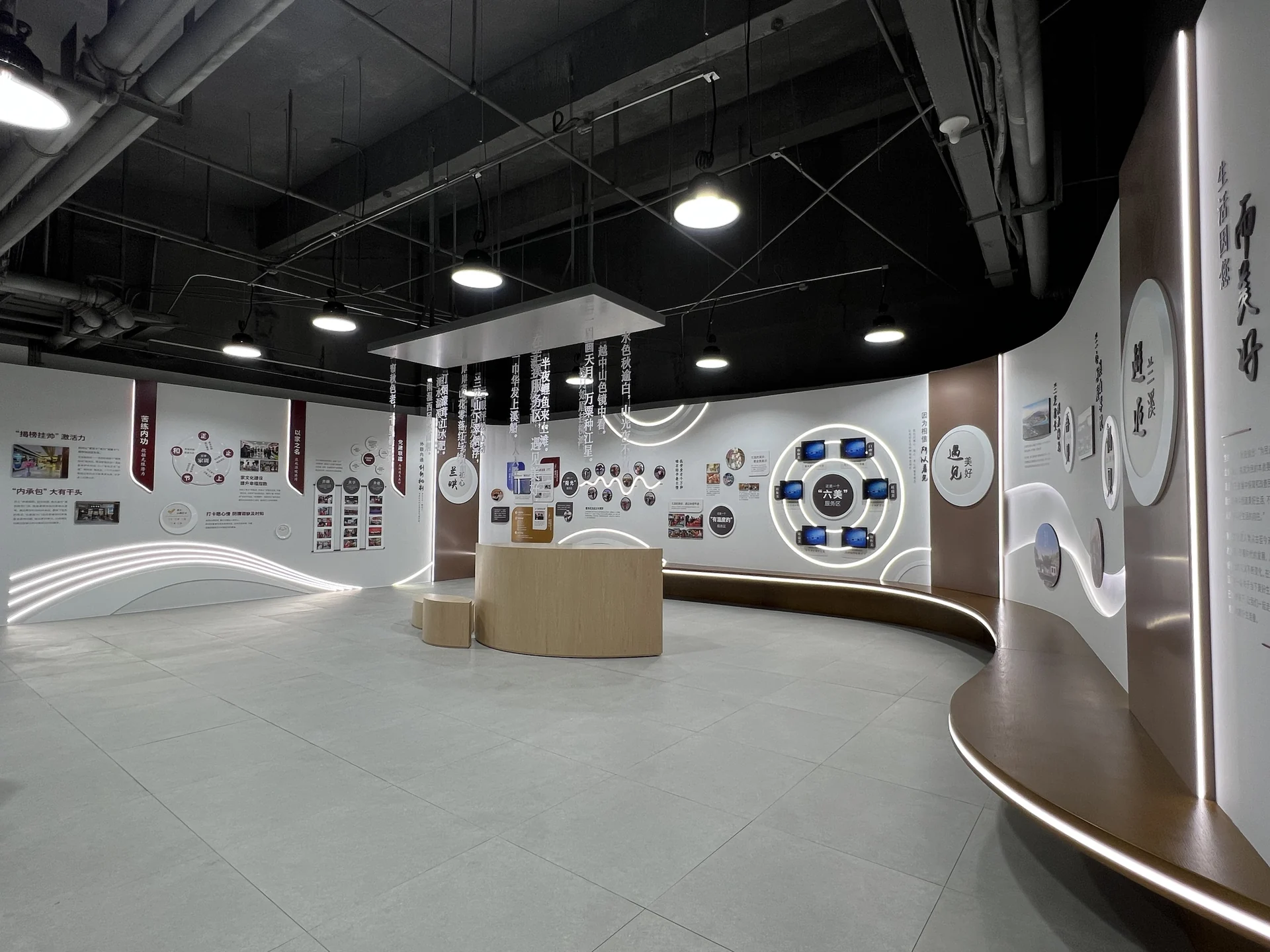 建成后的展厅全景:弧形主墙、中庭座凳和顶部诗词吊挂,黑色裸顶配筒灯,实拍
